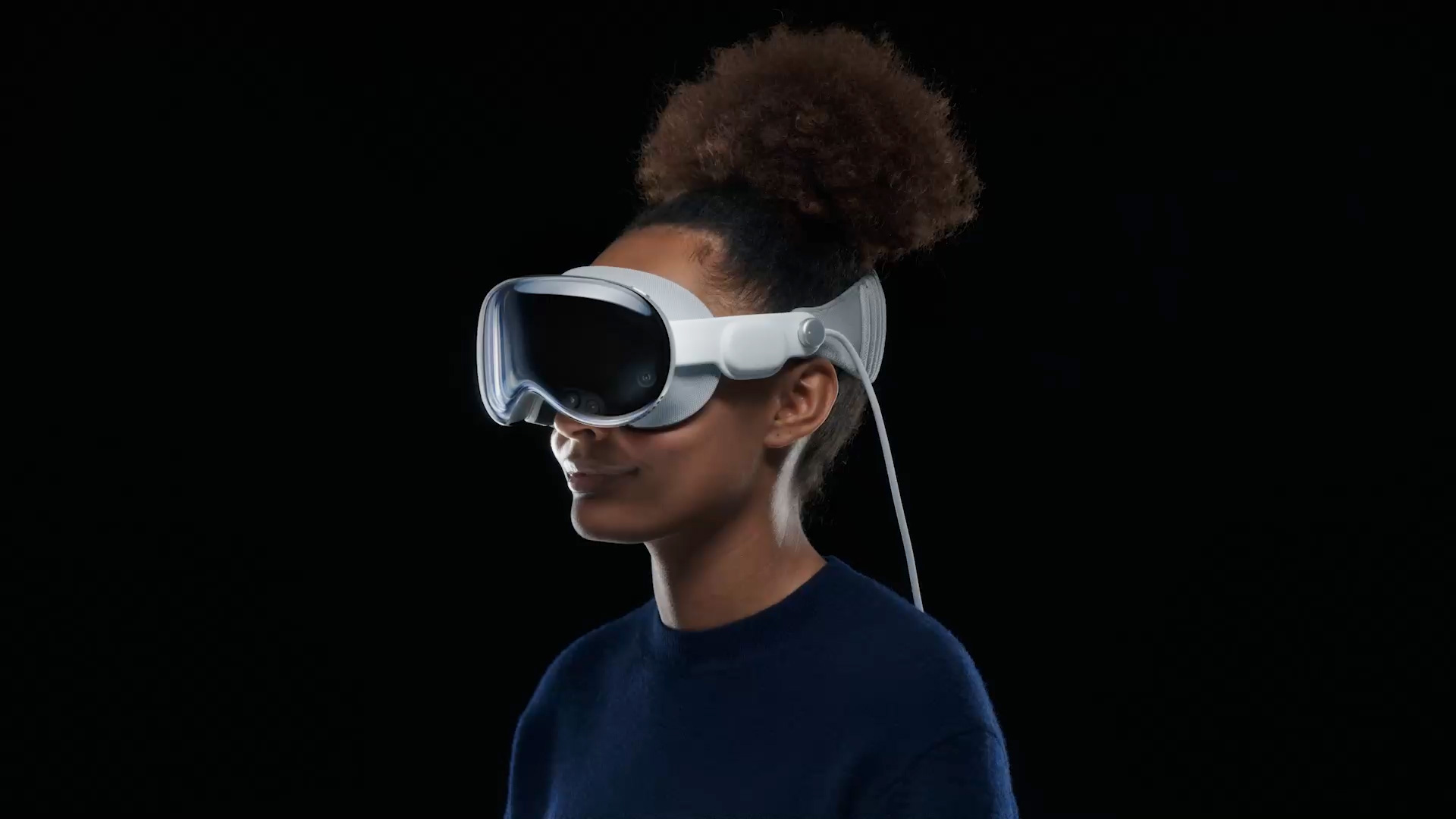 Frau trägt das Vision Pro-Headset von Apple mit Solo Knit Band vor einem schwarzen Hintergrund