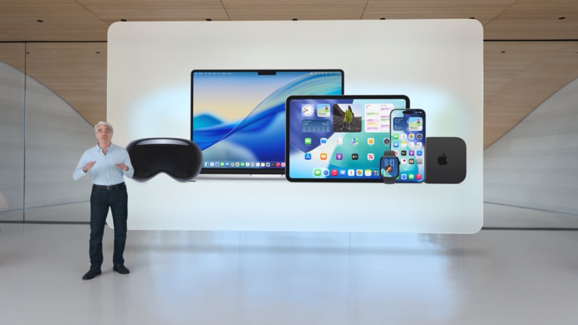 Craig Federighi standing in front of a slide showcasing the Liquid Glass design on the iPhone, iPad, Mac and other devices.